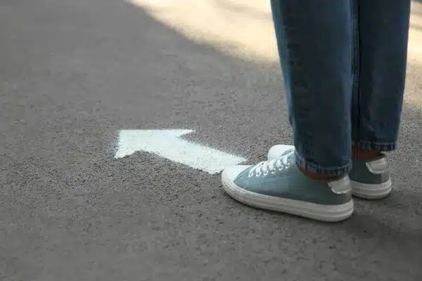 depositphotos_436134074-stock-photo-person-standing-arrow-asphalt-closeup